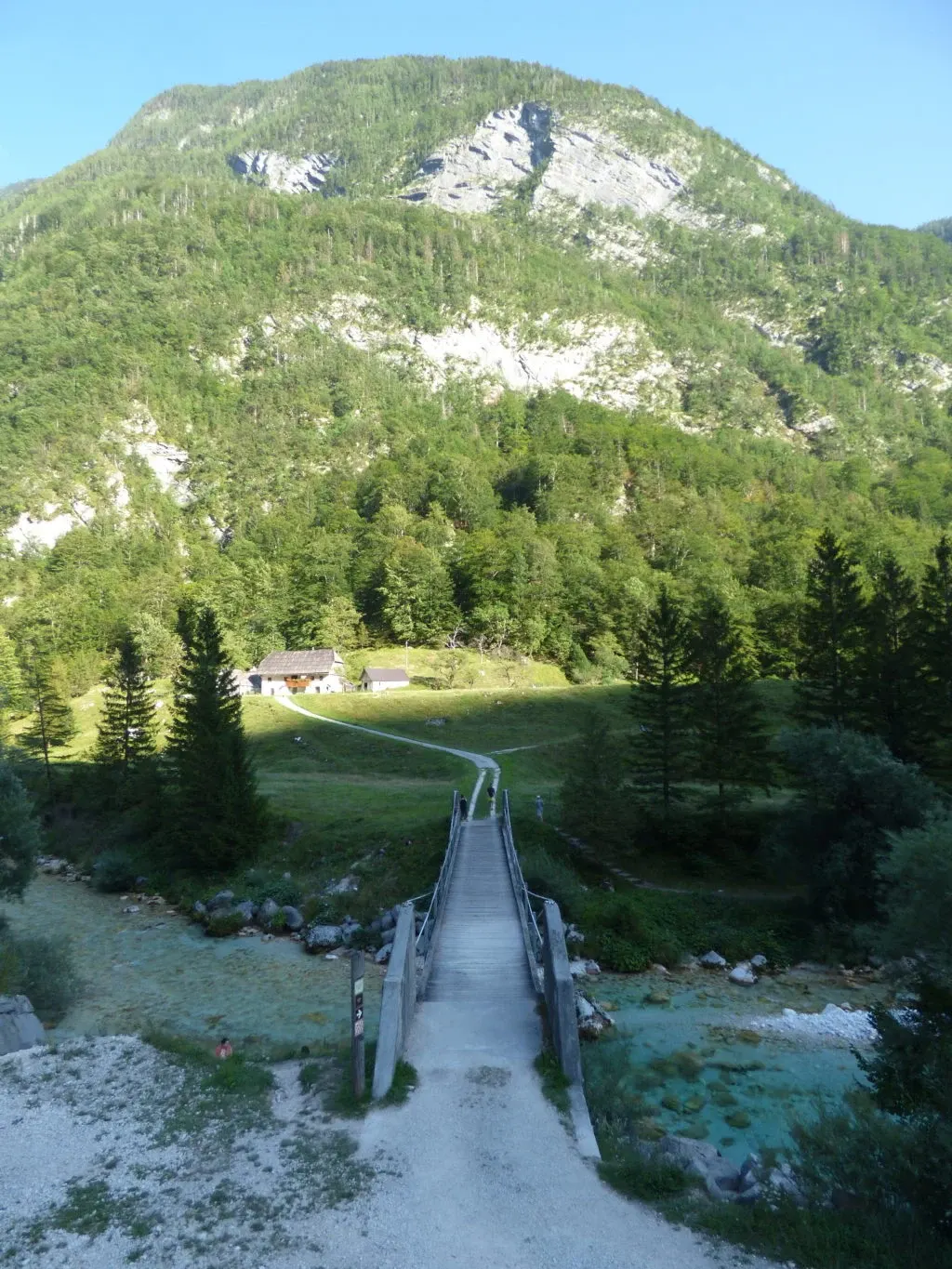 Passerelle de bois traversant la rivière vers un chalet isolé