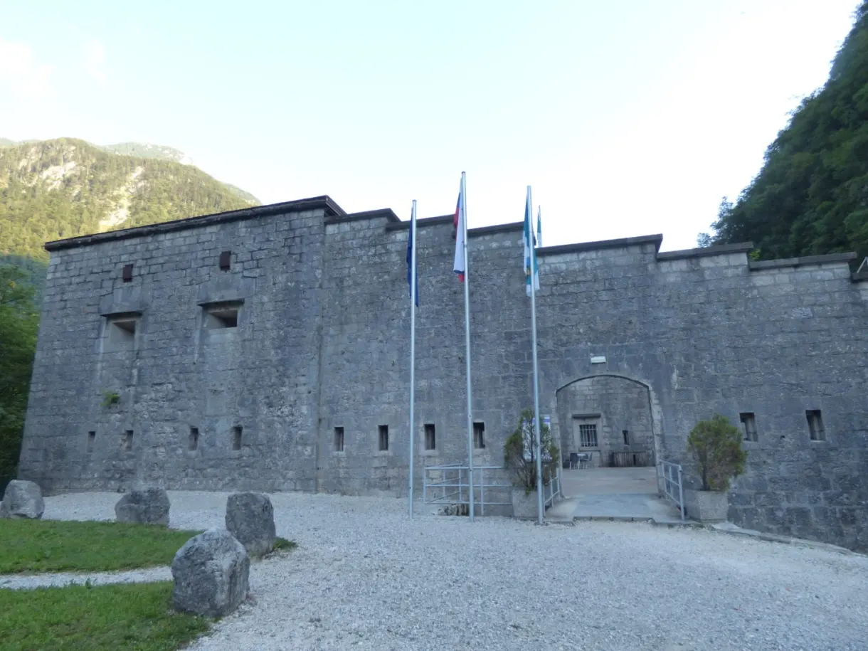 Façade du fort Kluže et ses drapeaux sur une cour de gravier