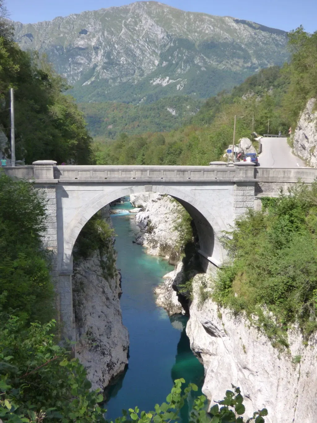Pont de pierre en arche enjambant la rivière vert profond