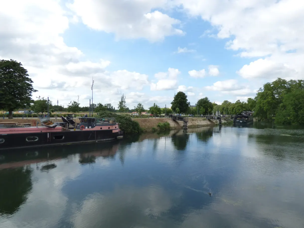 Péniche amarrée le long d'un canal bordé de verdure