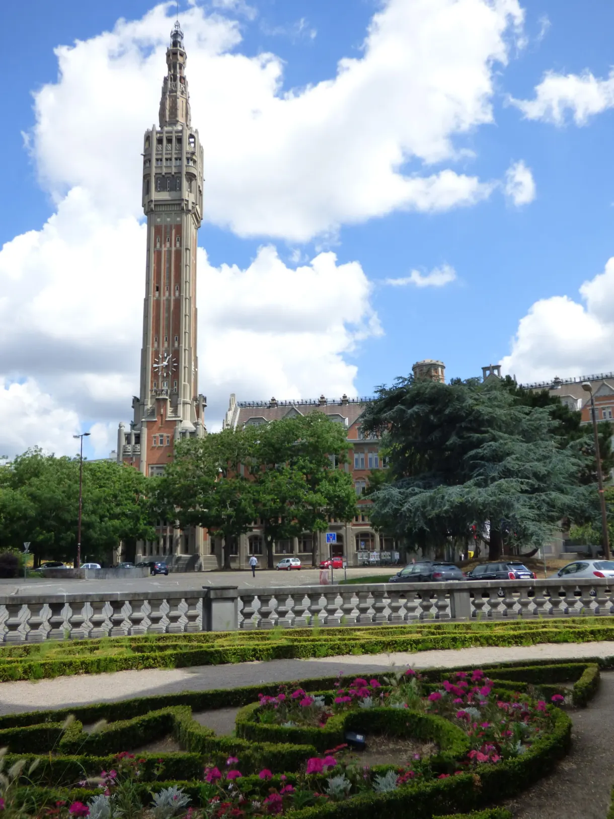 Beffroi de l'hôtel de ville vu depuis un jardin fleuri