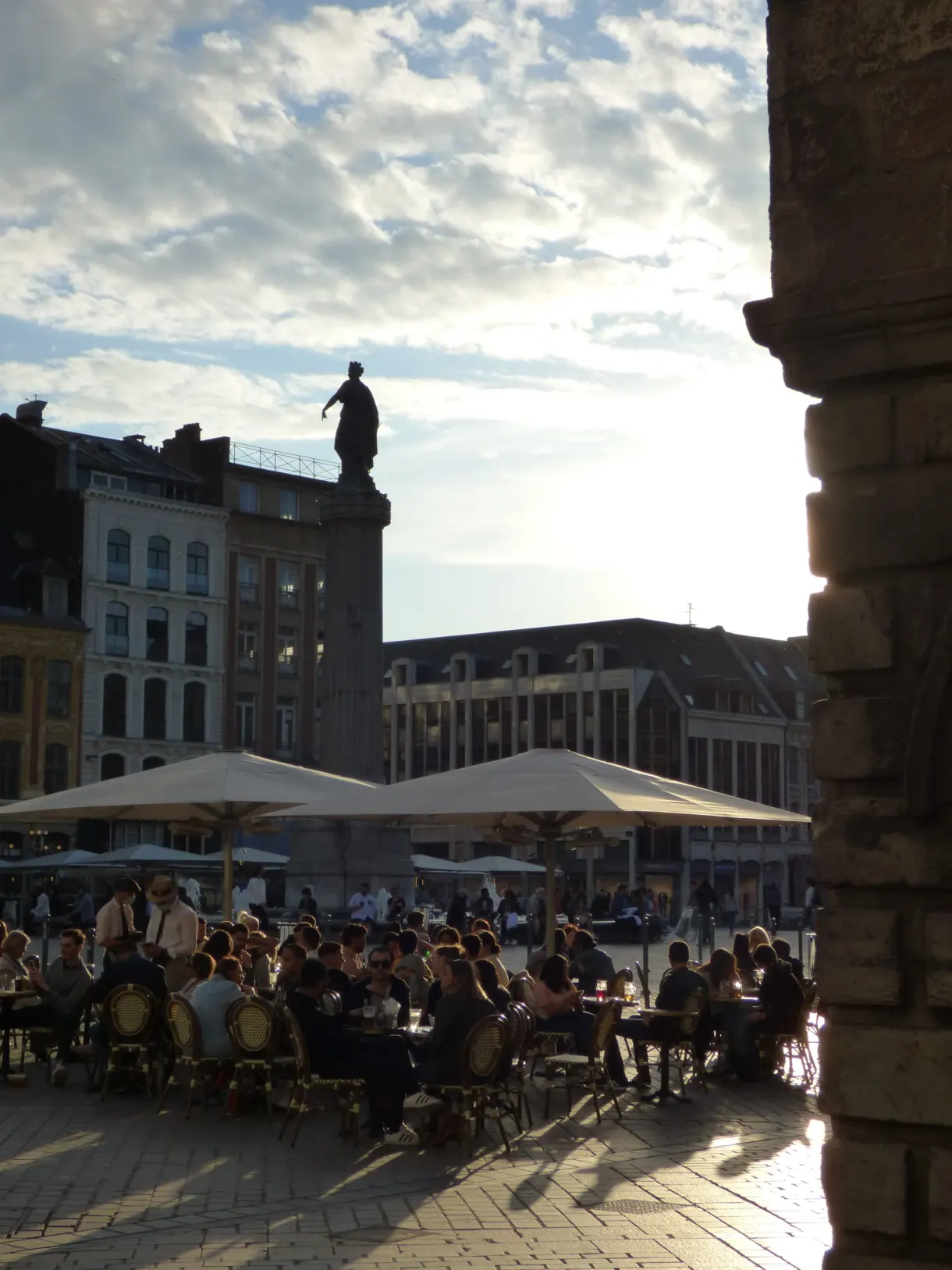Terrasse de café à contre-jour vue depuis une arcade