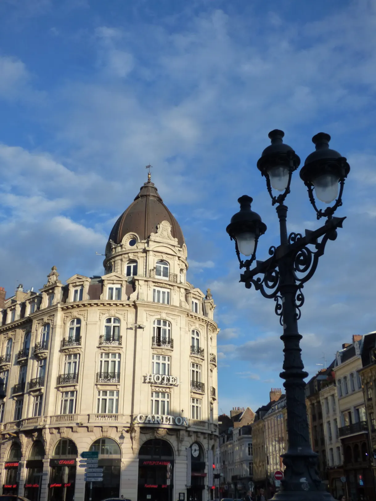 Immeuble d'angle et lampadaire ouvragé sur fond de ciel bleu