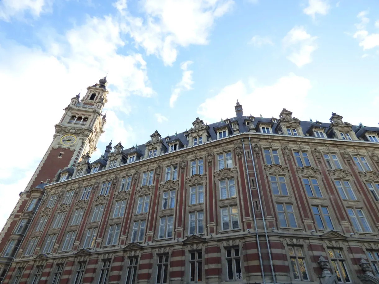 Contre-plongée sur une façade rayée de brique et de pierre