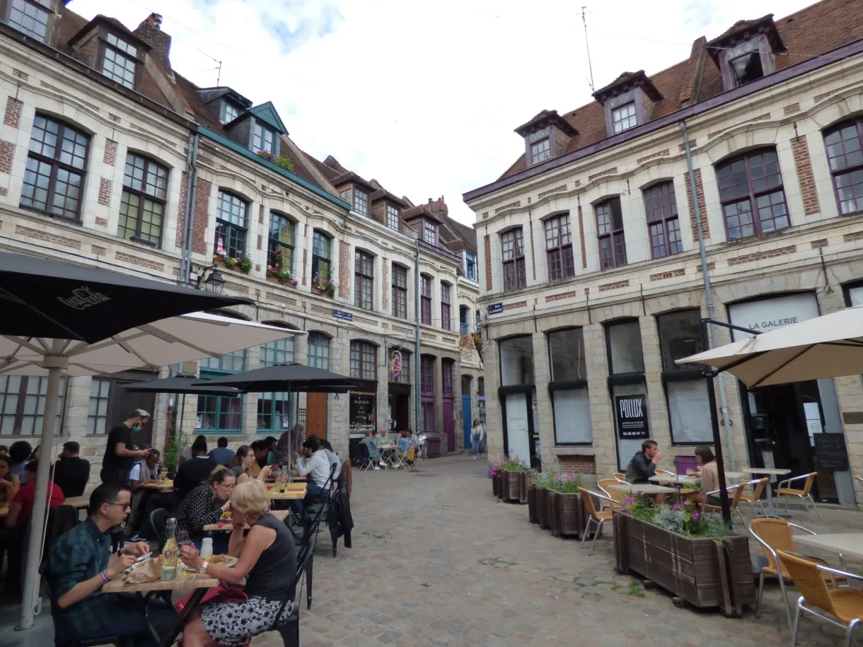 Terrasses et parasols au milieu d'une place pavée