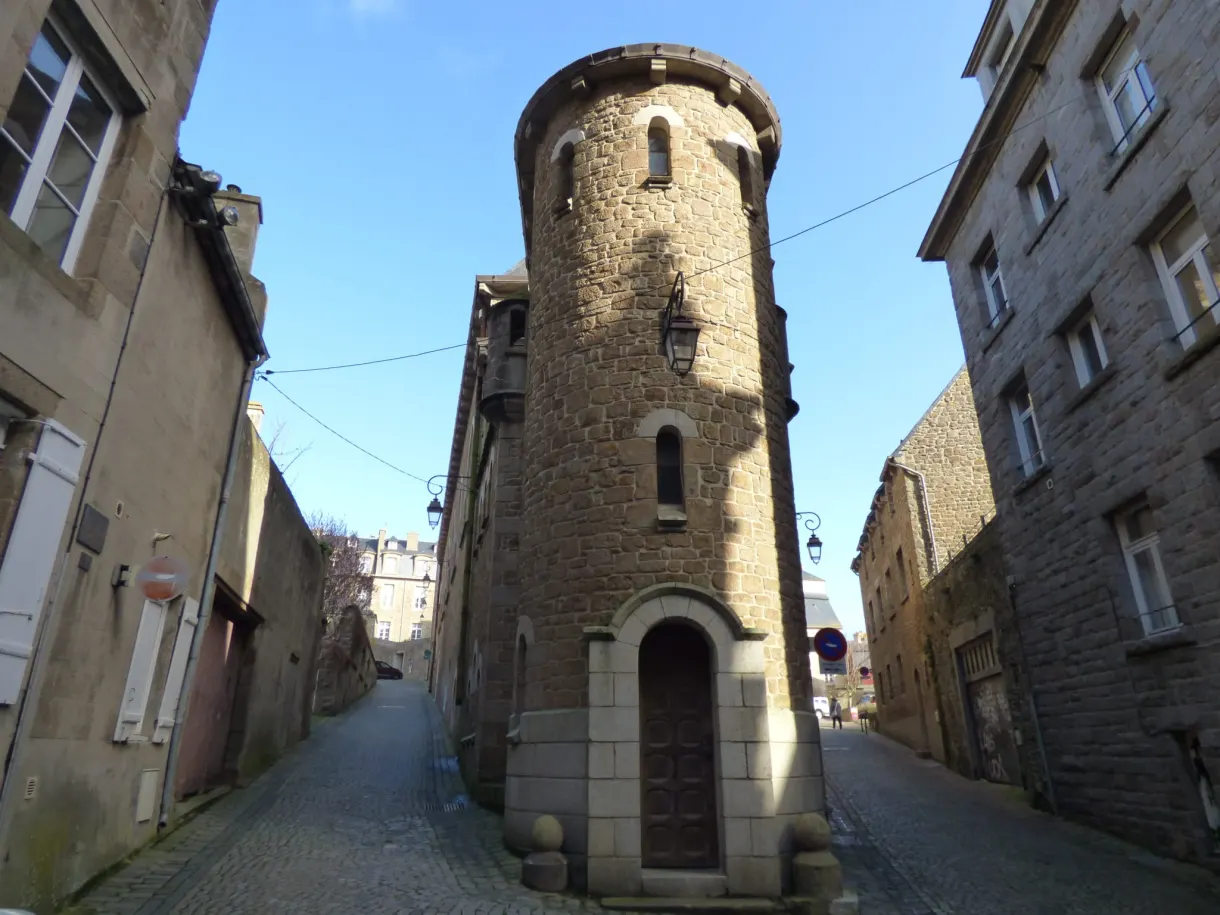 Tourelle ronde de pierre fermant une ruelle pavée