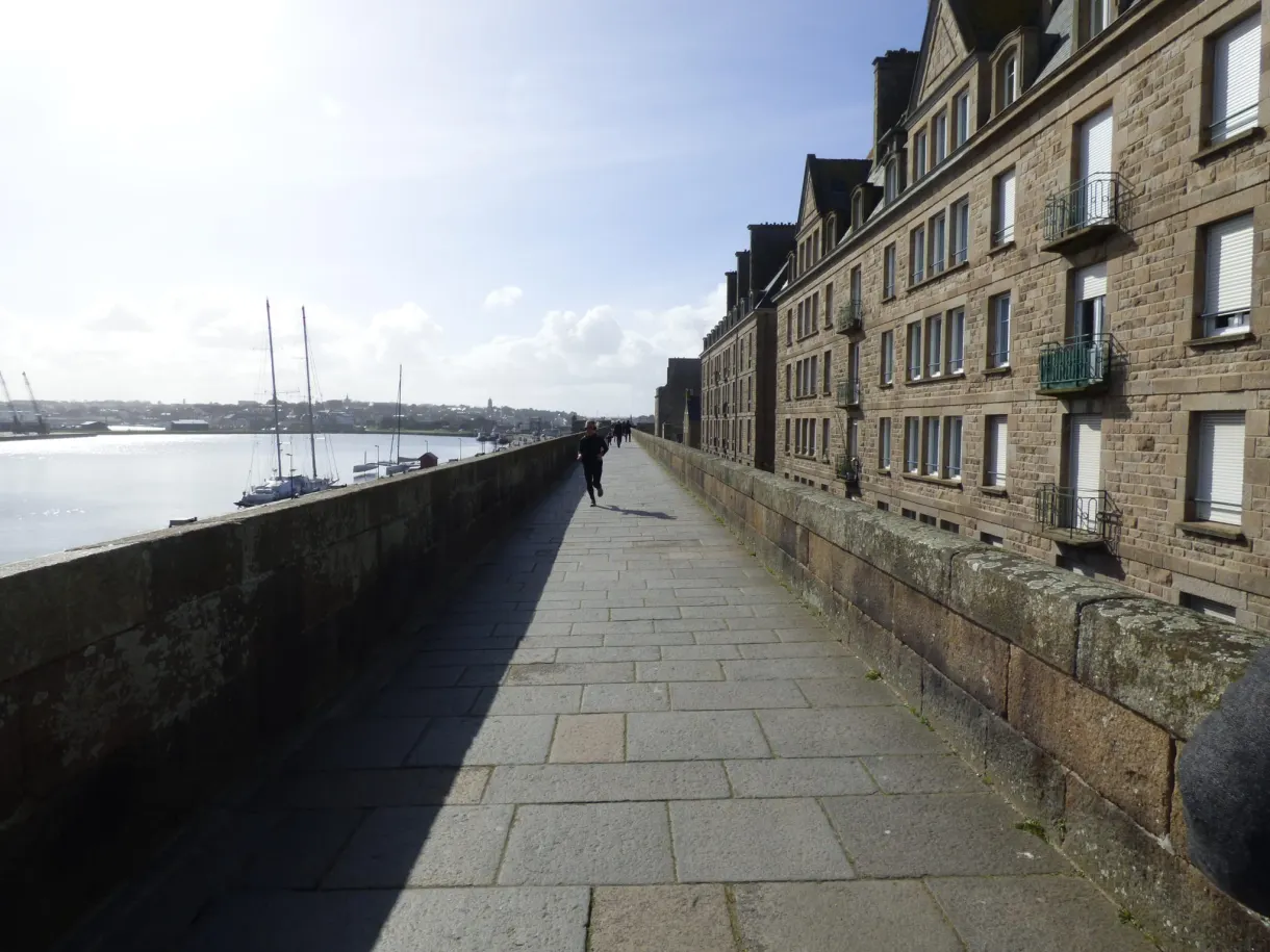 Chemin de ronde dallé longeant les immeubles jusqu'à la mer