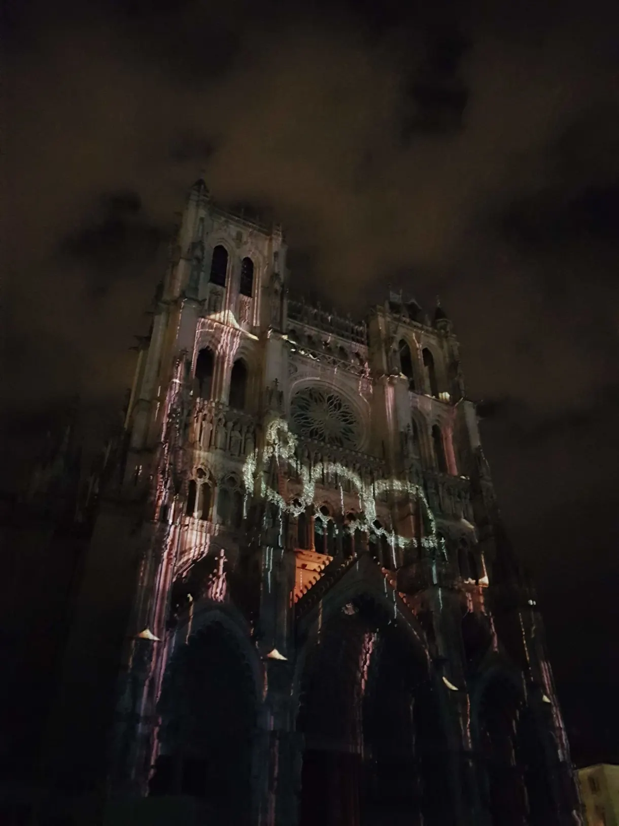 Cathédrale gothique baignée d'une projection lumineuse nocturne