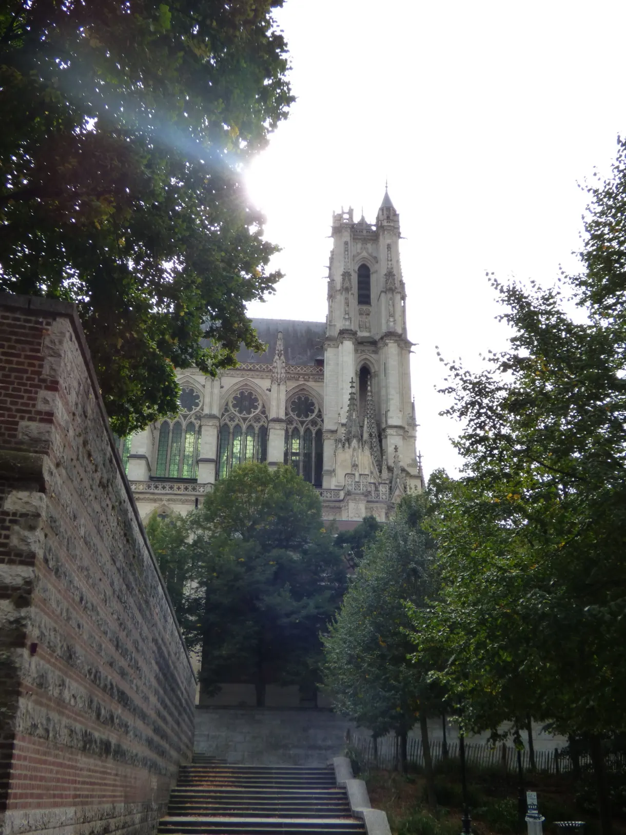 Escalier de brique montant vers le clocher entre les arbres