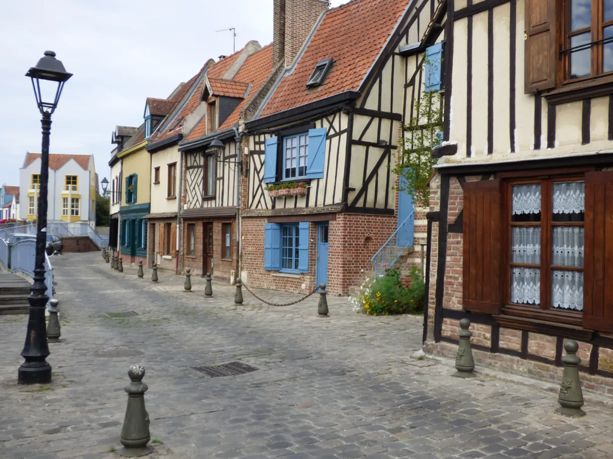 Rue pavée bordée de maisons à colombages aux volets colorés