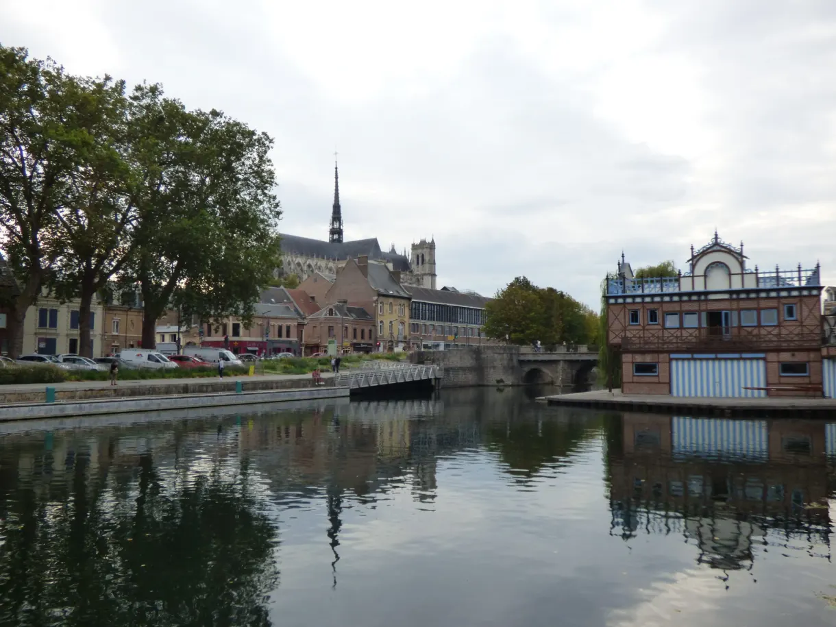 Bras de rivière reflétant les toits et un pont du centre-ville