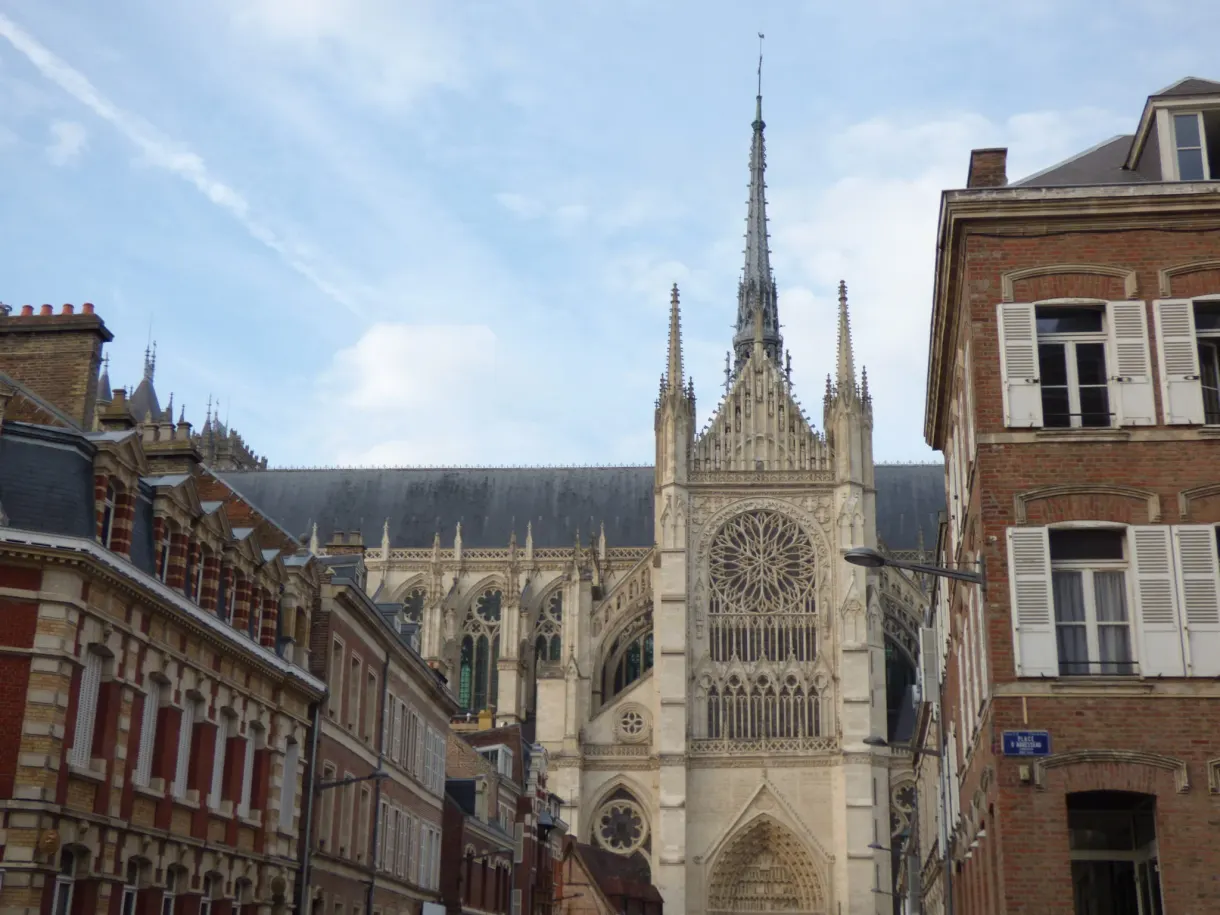 Flanc de la cathédrale et sa rosace vus depuis une rue de brique