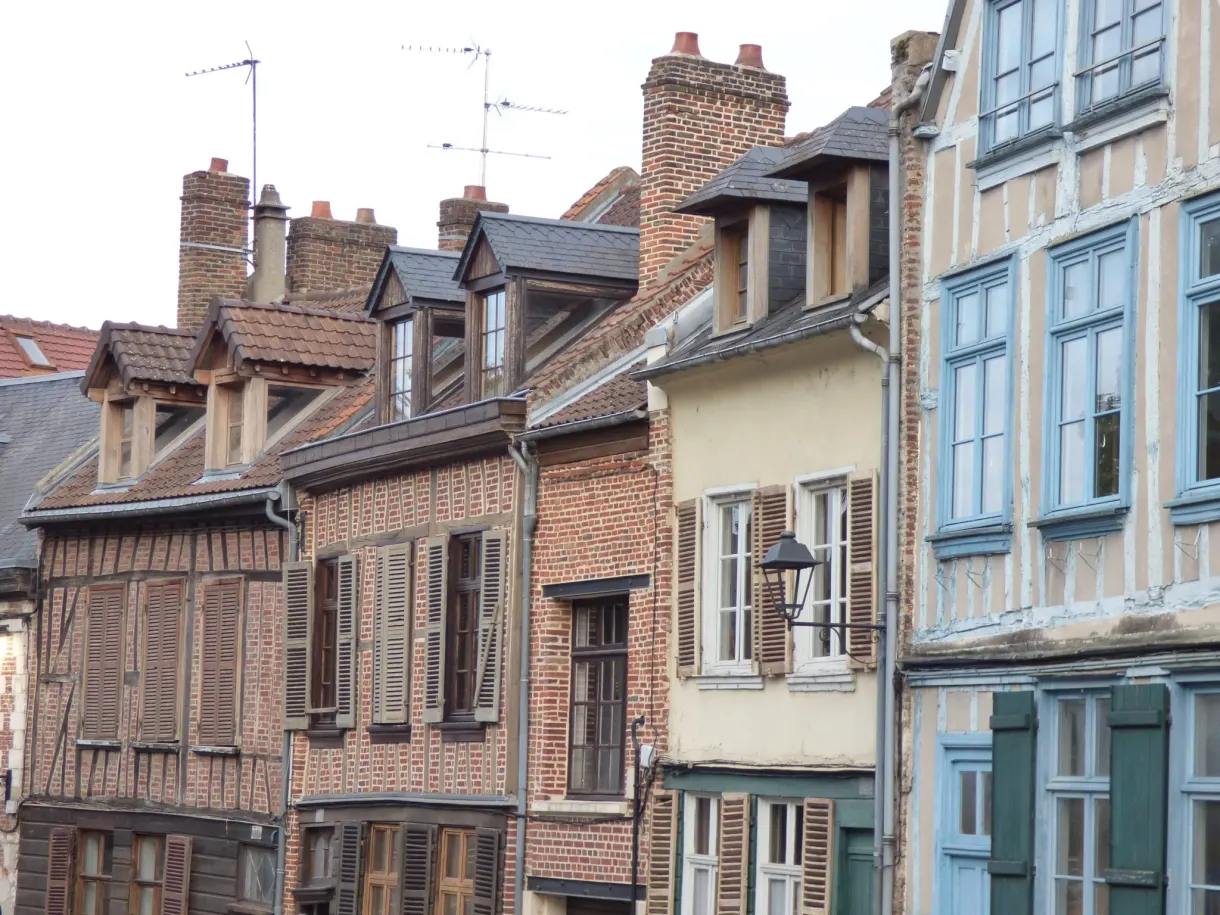 Alignement de façades de brique et de colombages aux fenêtres bleues