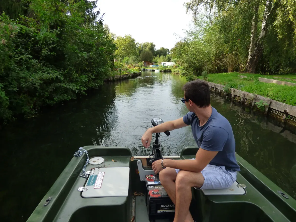 Barreur assis à l'arrière de la barque à moteur électrique