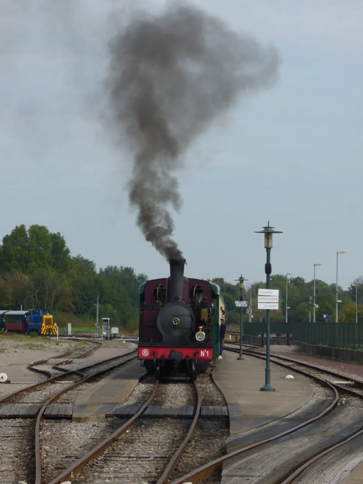 Colonne de fumée noire au-dessus de la locomotive en gare