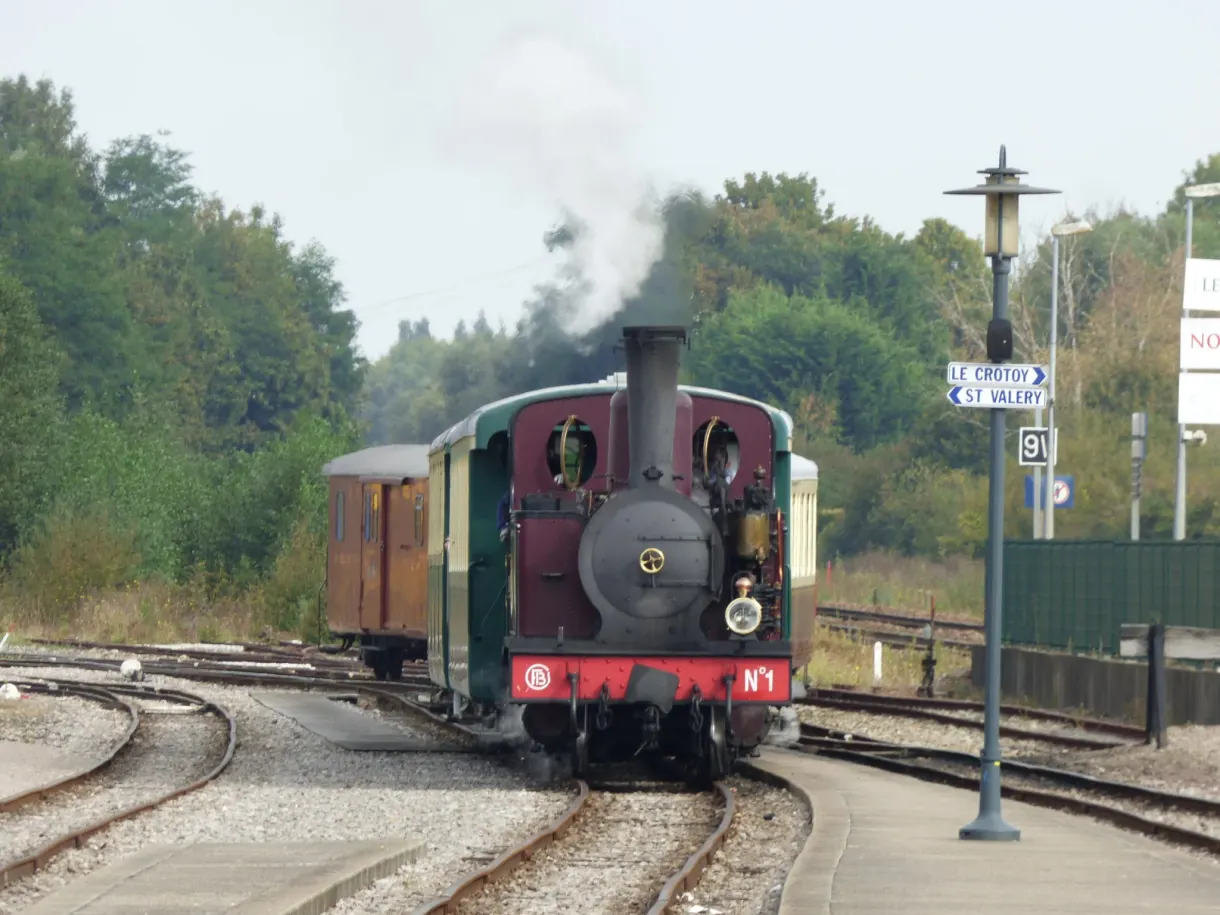 Locomotive à vapeur verte et rouge manœuvrant sur les voies