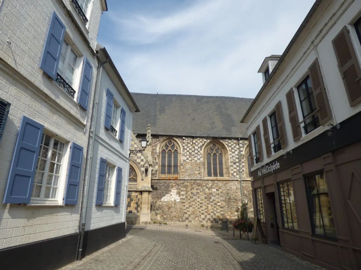 Maison aux volets bleus voisinant le chevet gothique d'une église