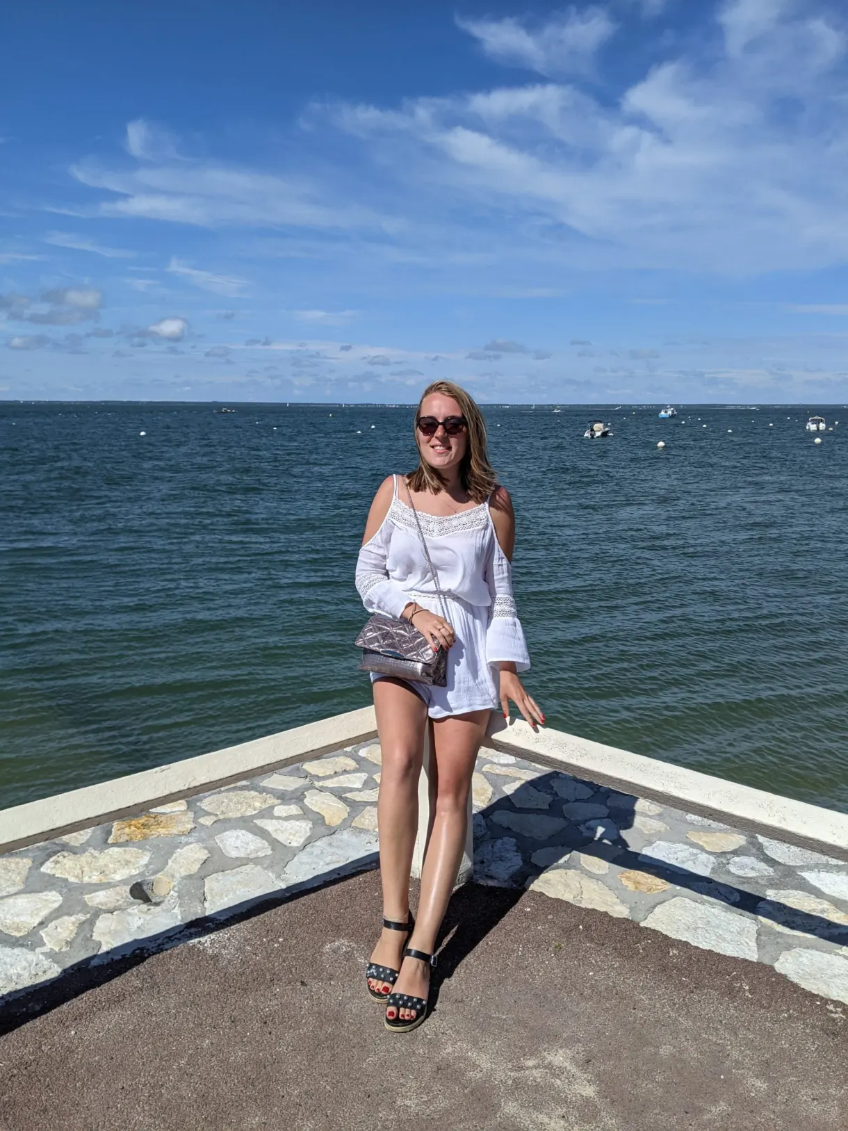 Sur la digue face au bassin, voiliers au mouillage