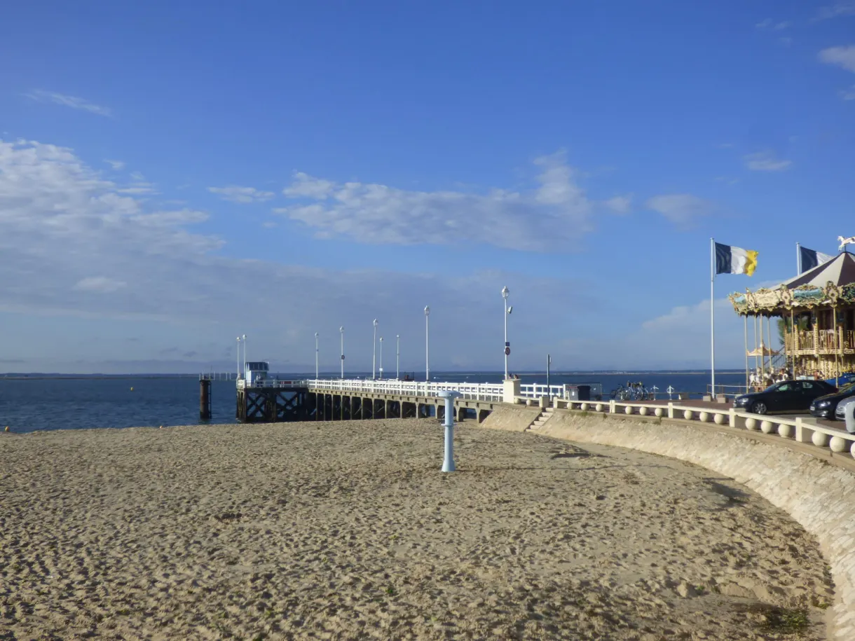 Jetée de bois et drapeaux au bout de la plage