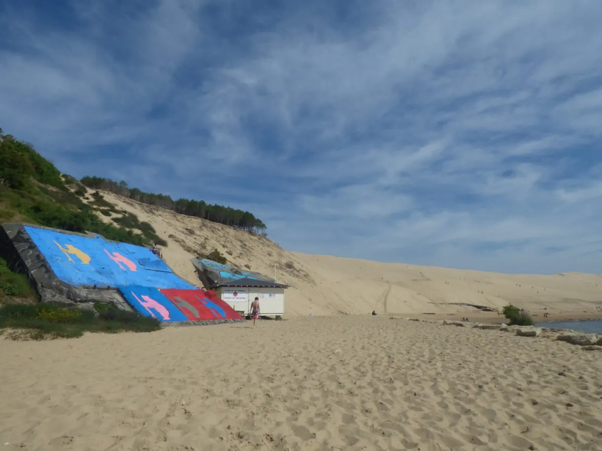 Cabane couverte de fresques au pied de la dune de sable