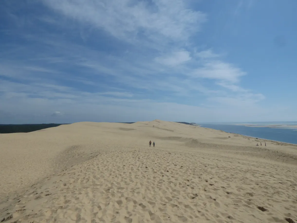 Crête de la dune parcourue par quelques promeneurs minuscules