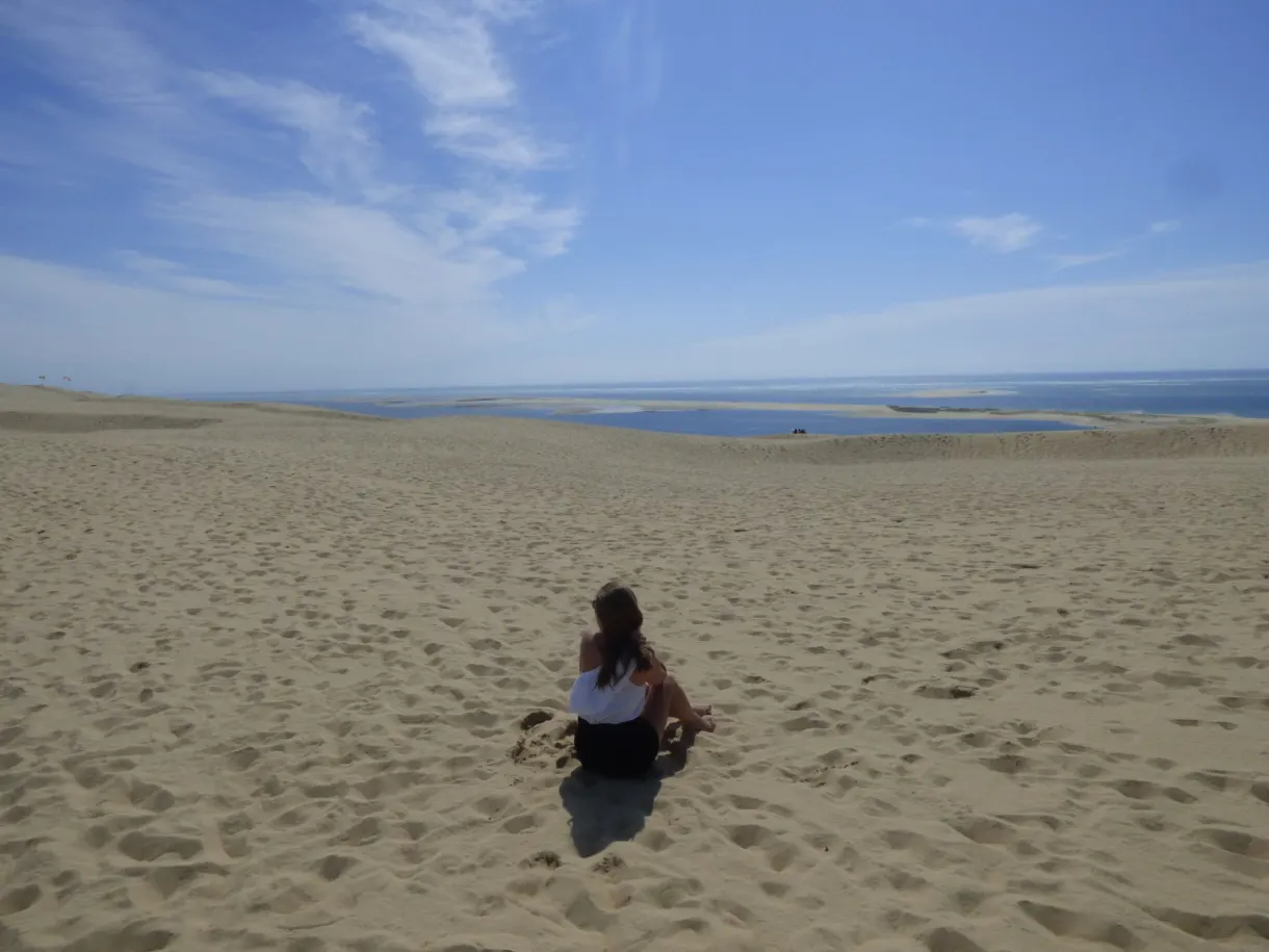 Assise dans le sable face au bassin et à l'horizon