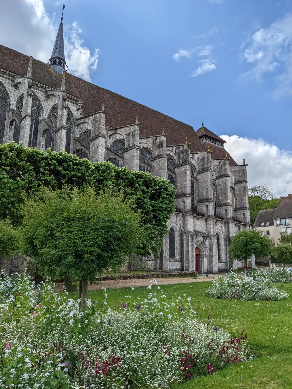 Église gothique cernée de massifs fleuris et de pelouse