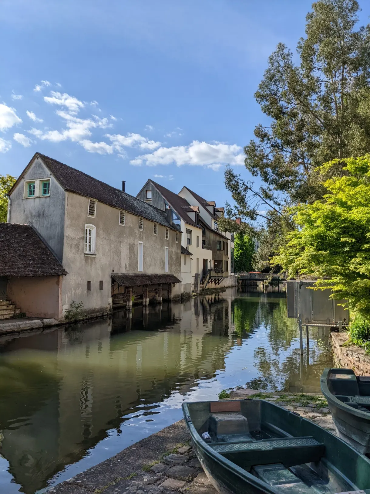 Barque verte amarrée au pied des vieilles maisons riveraines